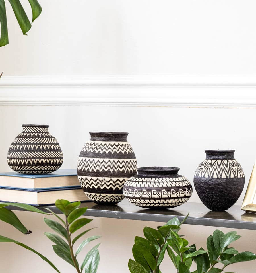 Small collectible woven baskets displayed on shelf, handwoven by indigenous Wounaan artisans using palm fiber