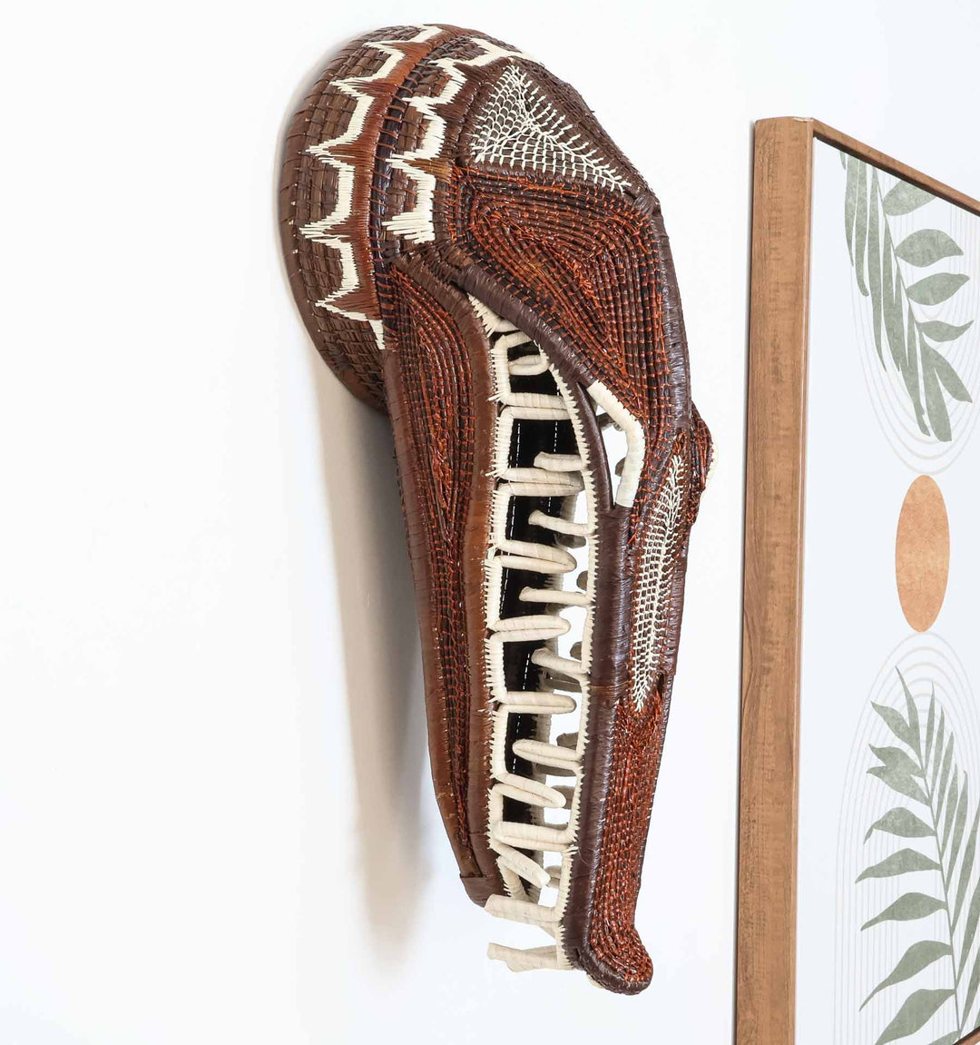 Angled view of handwoven crocodile mask with ladder-like designs