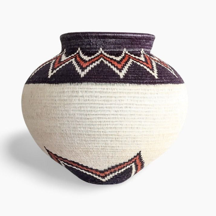 Woven basket with geometric pattern on a white background