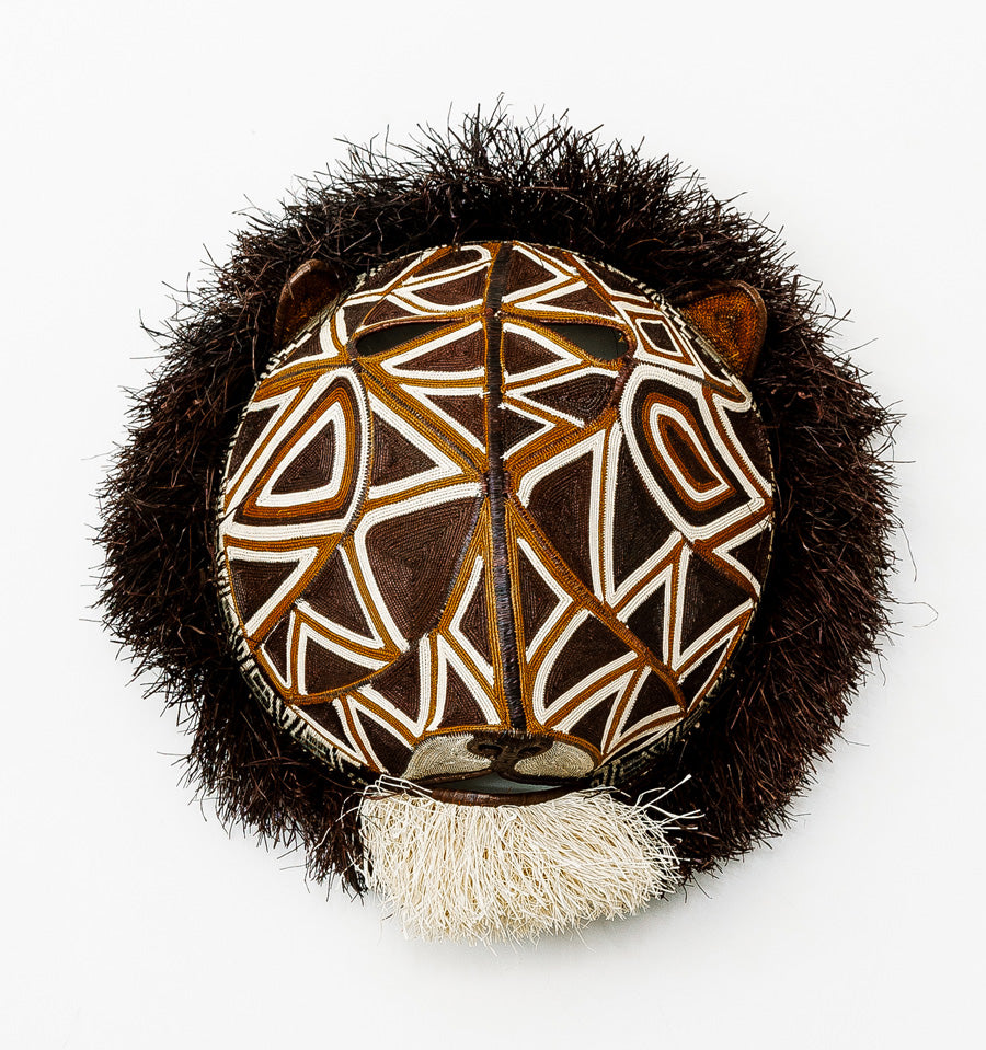Geometric Cat Mask, woven art by Embera weaver Felicinda Guaynora, Panama palm fiber feline mask with bold white-lined geometric patterns, shaggy mane, and ivory beard.