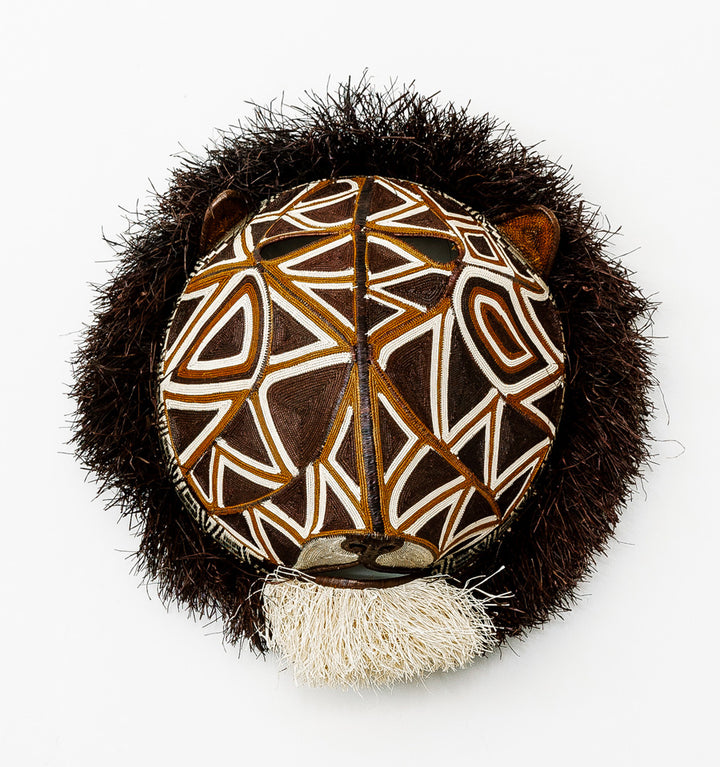 Geometric Cat Mask, woven art by Embera weaver Felicinda Guaynora, Panama palm fiber feline mask with bold white-lined geometric patterns, shaggy mane, and ivory beard.