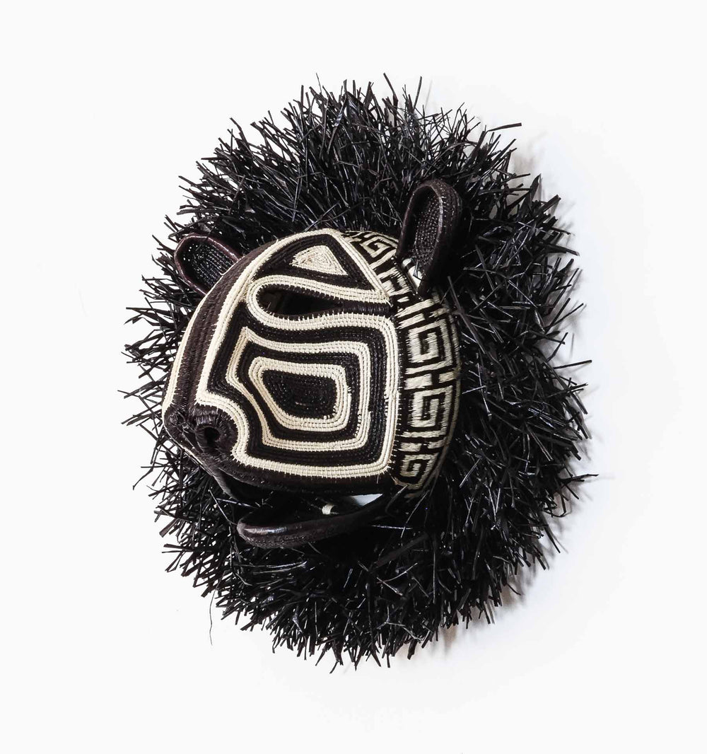 Side view of Embera cat mask by Felicinda Guaynora, woven in geometric black and ivory