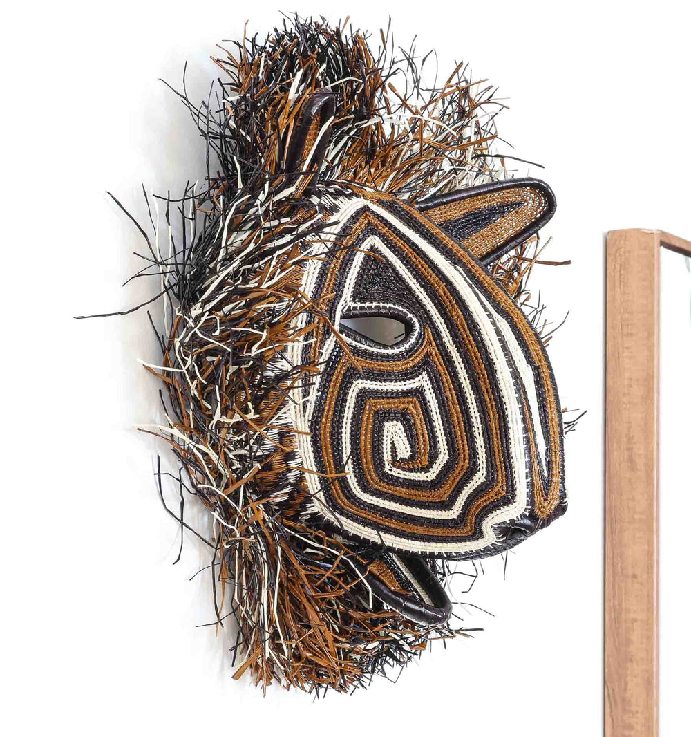Side angle of Embera cat mask with geometric zigzag patterns.
