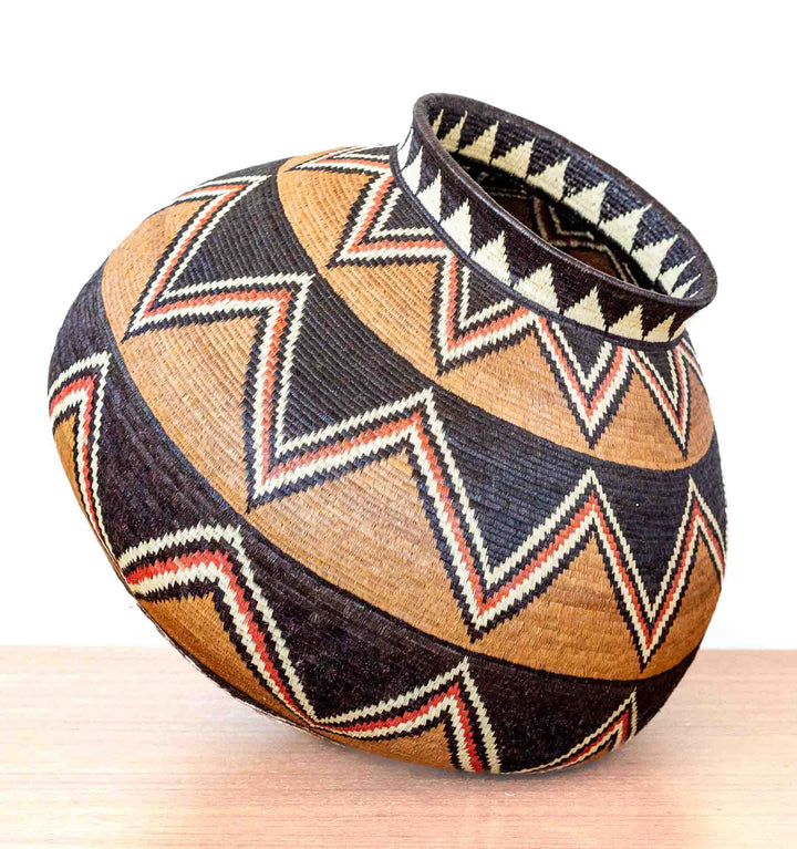 Side view of Ember Sunburst Wounaan basket showing bold zigzag bands