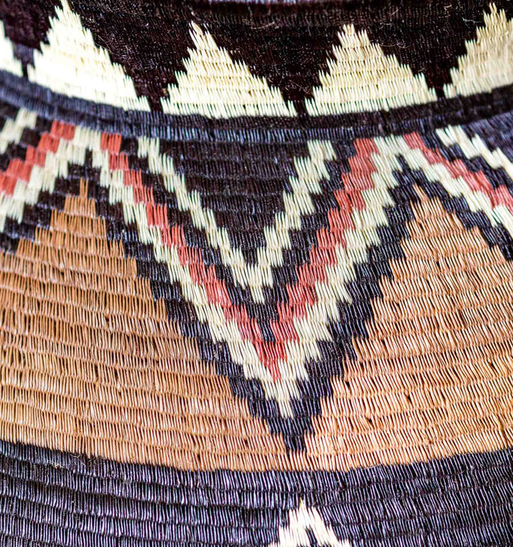 Close-up of Ember Sunburst Wounaan basket weave with red, black, and ivory zigzag pattern