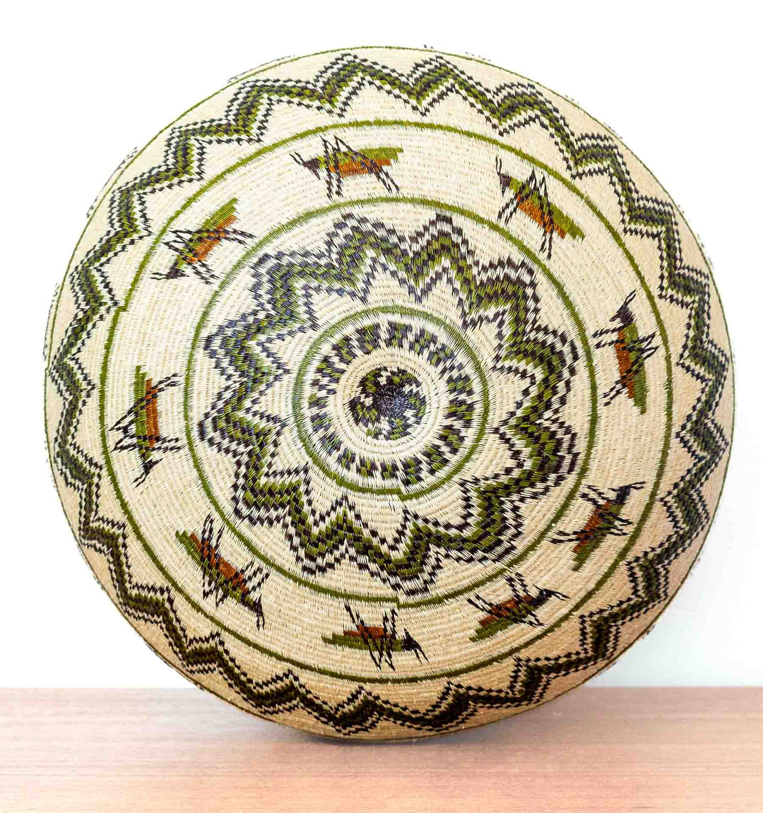Bottom view of basket with radiating zigzag and insect motifs.
