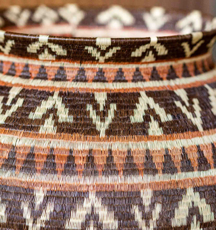 Close-up of rim and woven chevron design in orange, brown, and ivory on a Wounaan basket