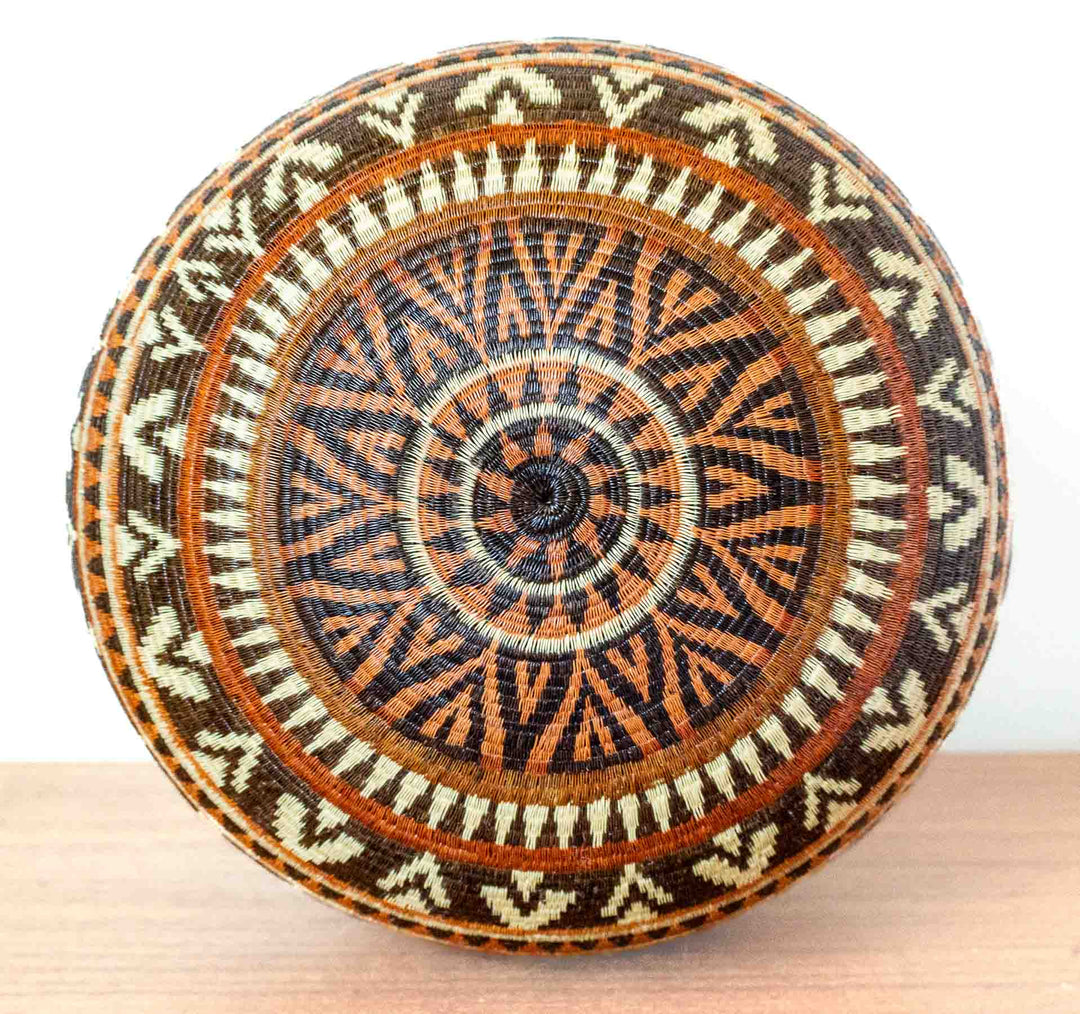 Bottom view of Ember Glow Chevron Wounaan basket with concentric chevron pattern.
