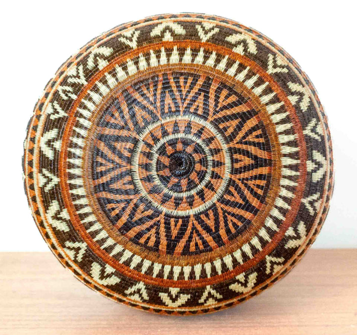 Bottom view of Ember Glow Chevron Wounaan basket with concentric chevron pattern.