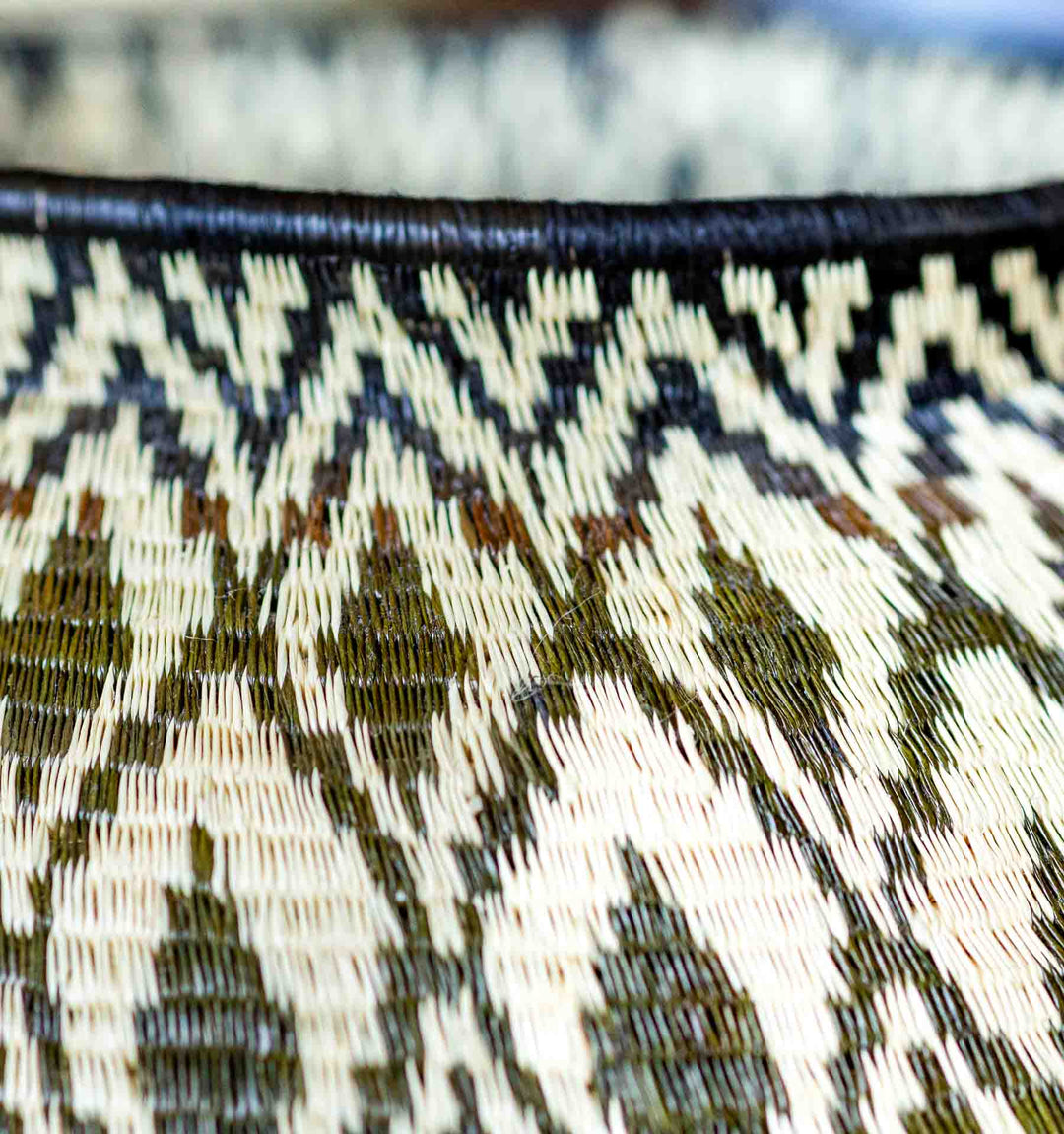 Close-up of rim detail on black and cream diamond-patterned Panama Wounaan basket