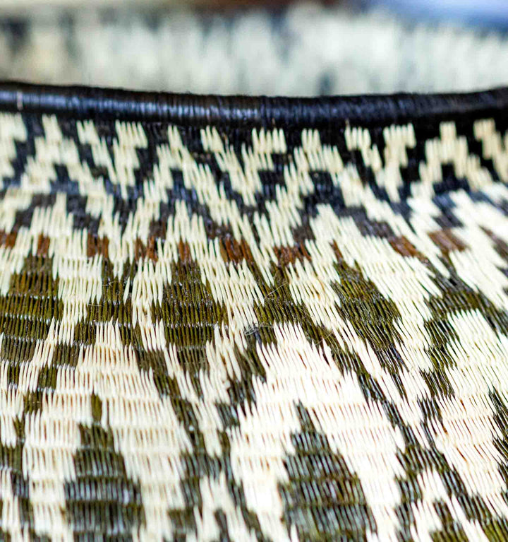 Close-up of rim detail on black and cream diamond-patterned Panama Wounaan basket