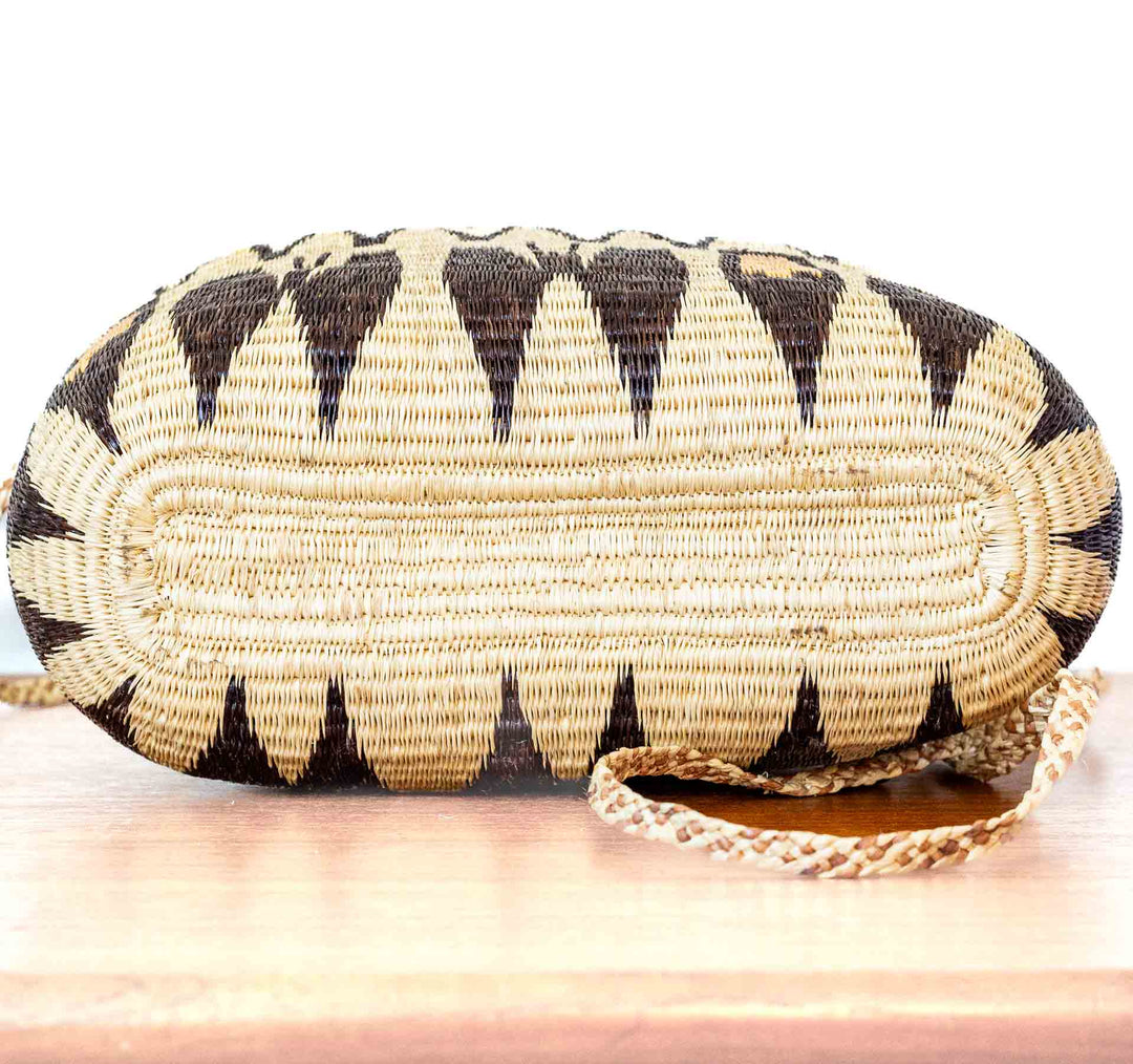 Side view of golden and brown geometric Wounaan basket purse