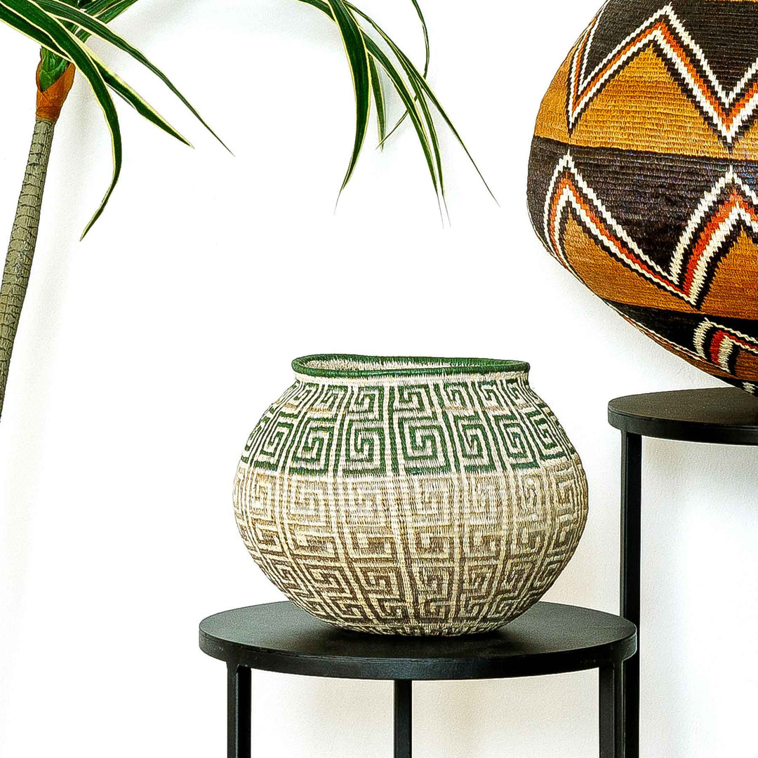 Handwoven Panama Wounaan basket with green and brown labyrinth pattern, natural palm fiber and intricate geometric design.