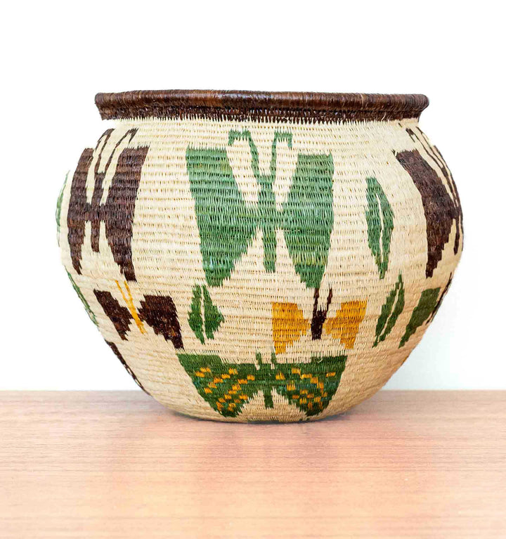 Full side view of Panama Wounaan butterfly basket featuring symmetrical butterfly patterns