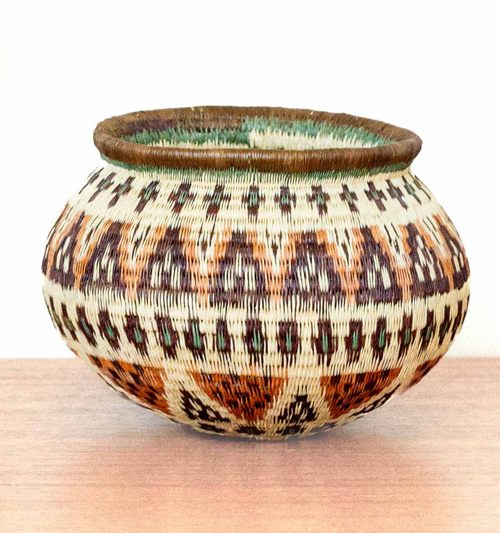 Full view of Ember Glow Wounaan Basket with green rim detail and patterned body