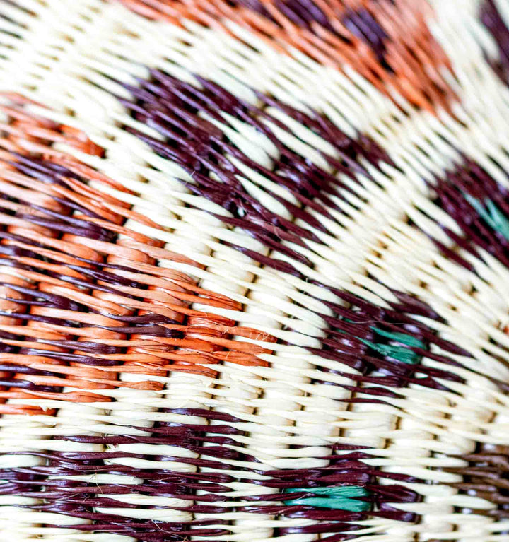 Close-up of Ember Glow Wounaan Basket showing fine palm fiber weaving in rust, plum, and cream