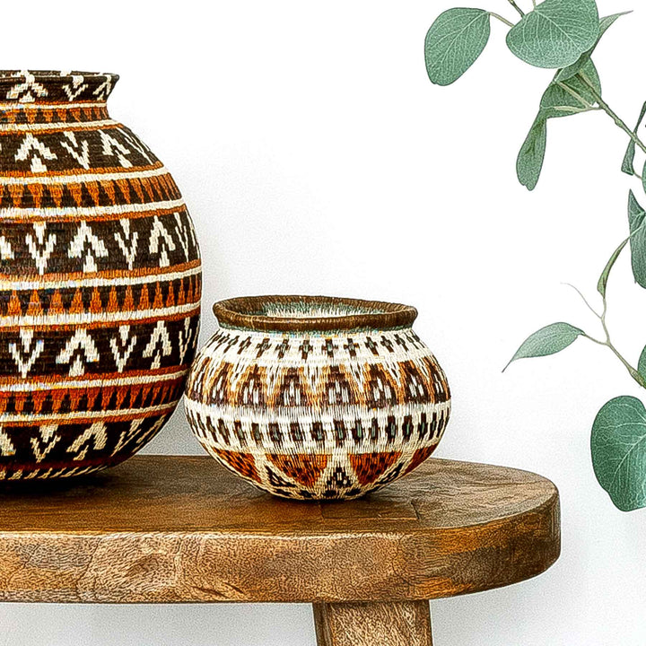 Ember Glow Wounaan Basket styled on wooden table beside a larger woven piece.