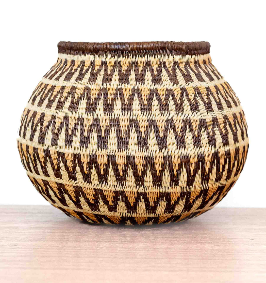 Decorative Wounaan basket with sunburst wave motif, handwoven in Panama with natural palm fibers.