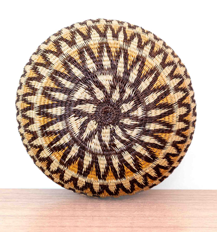 Overhead view of handwoven Wounaan basket showing sunburst wave design radiating from the center