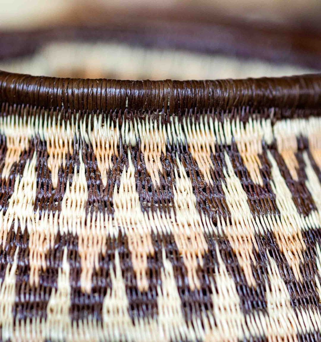 Detail view of Wounaan basket weave showing wave-like geometric motif in natural palm fiber.