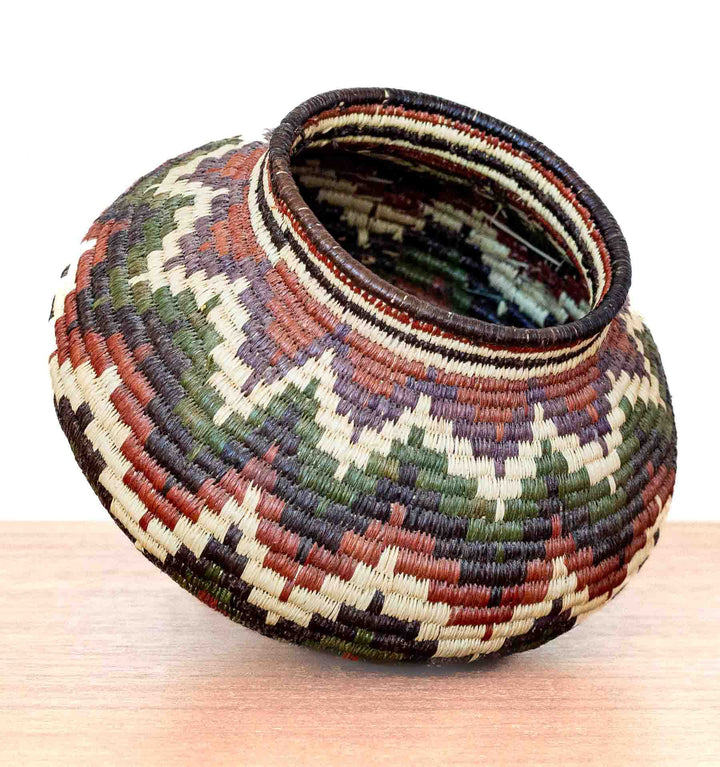 Handwoven Wounaan basket in chevron pattern with natural rainforest-inspired colors, crafted in Panama.