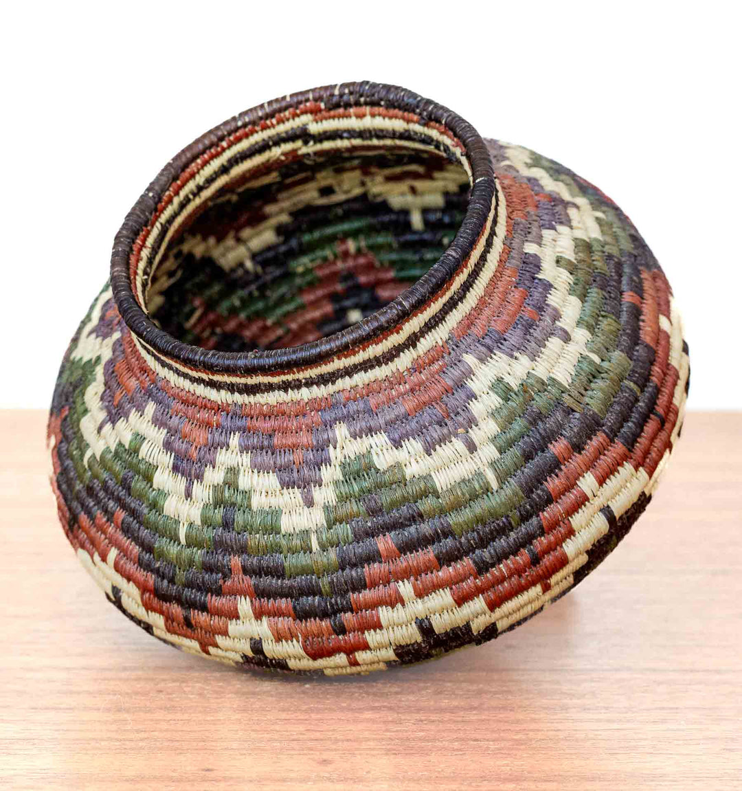 Panamanian Wounaan basket with colorful chevron design, handwoven from dyed palm fibers