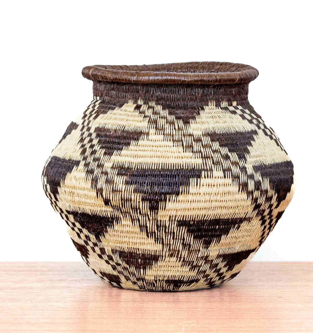 Handwoven Wounaan basket from Panama with angular body and stepped diamond motif in black and ivory tones