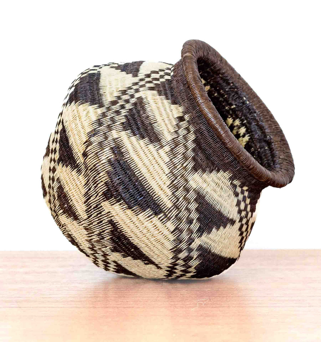 Handwoven Wounaan basket from Panama with stepped diamond pattern, shown tilted for display.