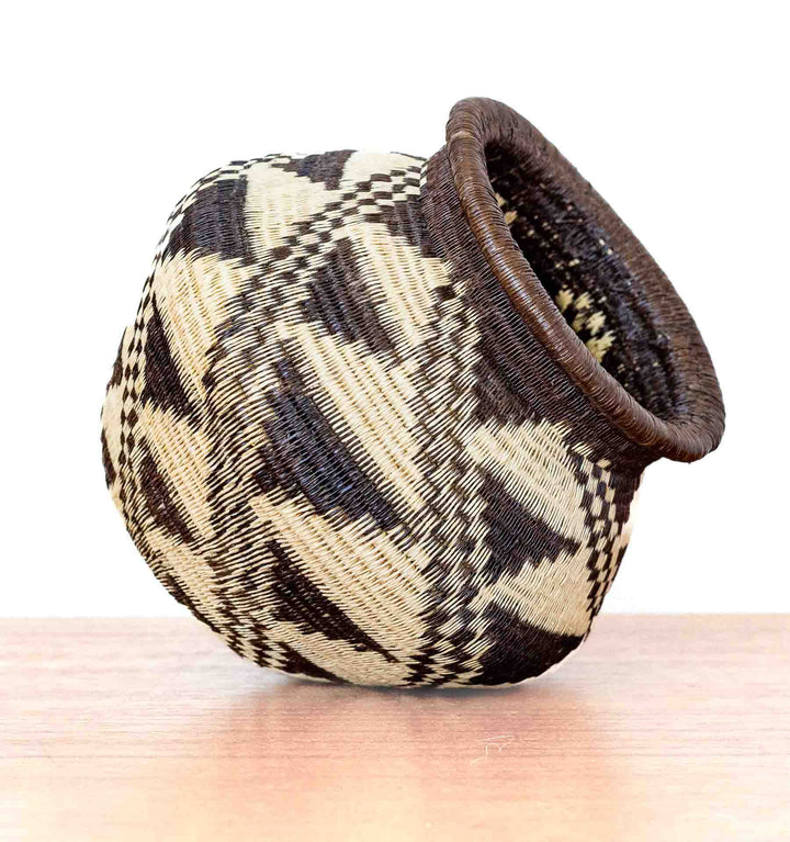 Handwoven Wounaan basket from Panama with stepped diamond pattern, shown tilted for display.