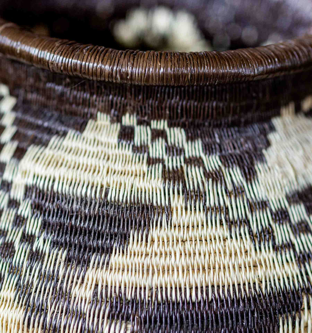 Close-up of Panamanian Wounaan basket rim with stepped diamond motif in black and ivory palm fiber.