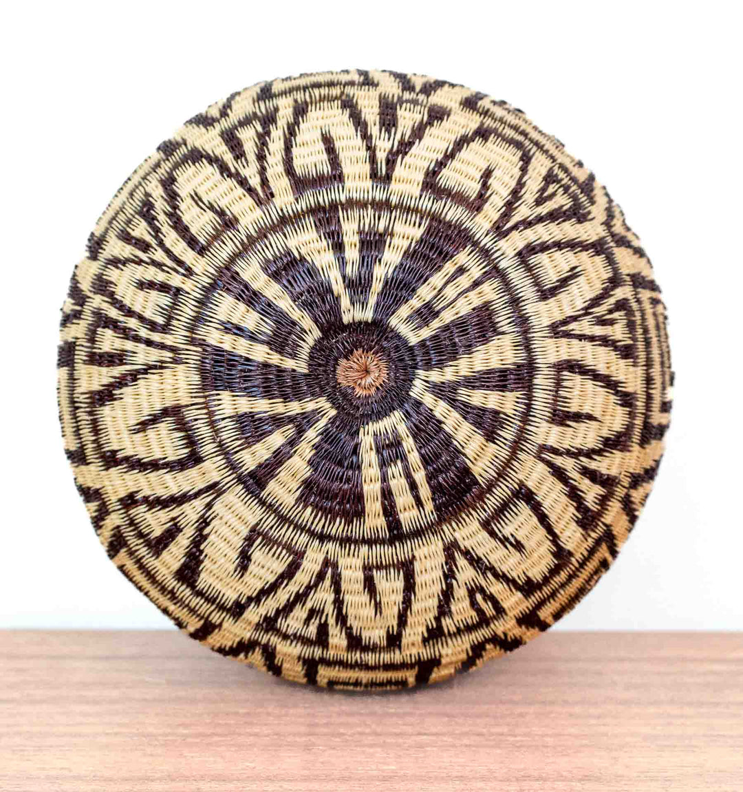 Overhead view of Panamanian Wounaan woven basket showing labyrinth-like circular geometric design.