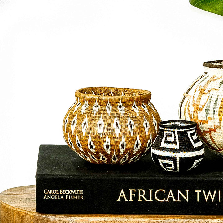 Panamanian Wounaan basket with flame pattern design, handwoven from natural palm fiber in brown, ivory, and black tones.